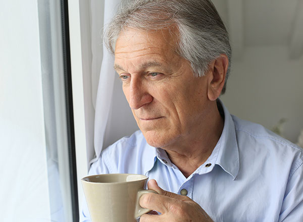 Man with coffee at window